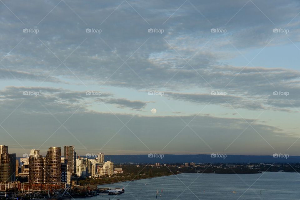 The view of cityscape from Kings Park, Perth, Western Australia at the time of dusk. The Swan River and the central business district can be seen with the moon.