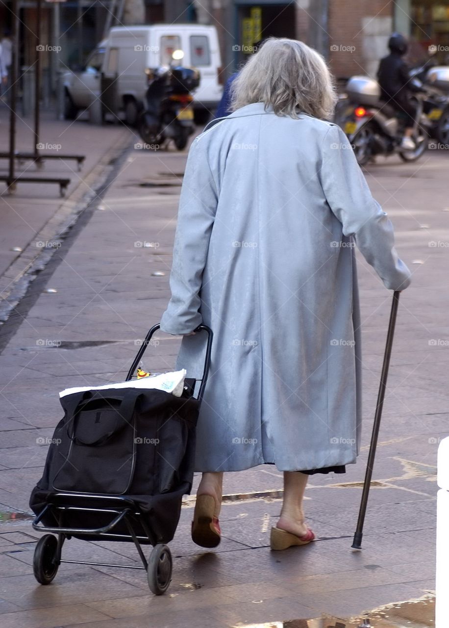 Old woman with difficulties by daily shopping