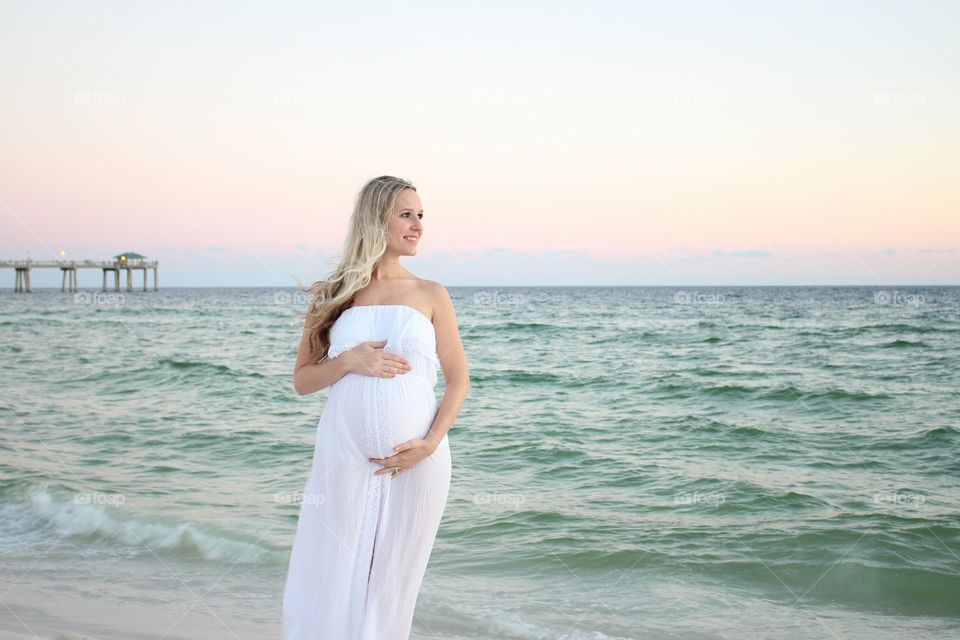 Pregnant woman standing at beach