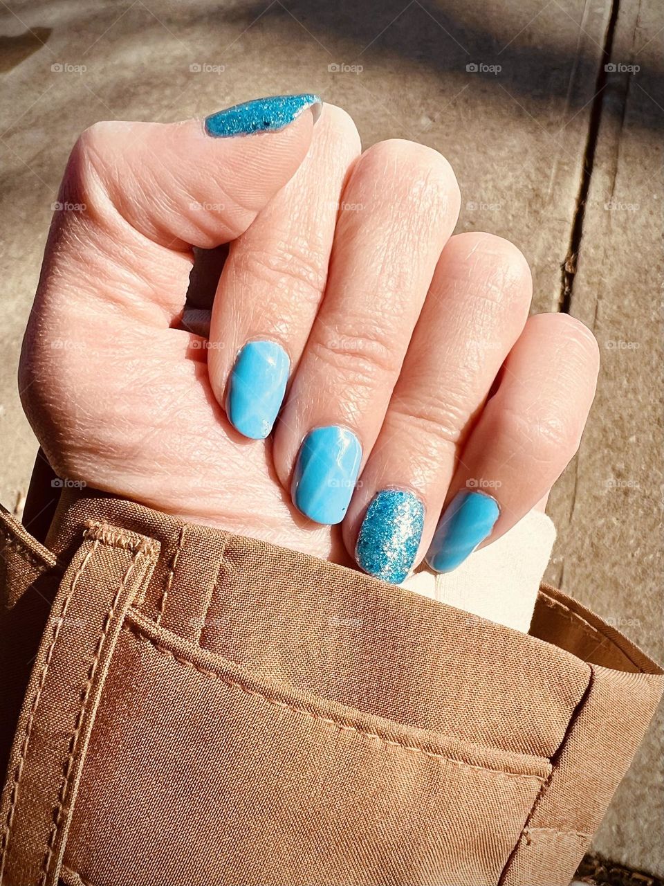 Bright blue sparkly gel nail manicure 