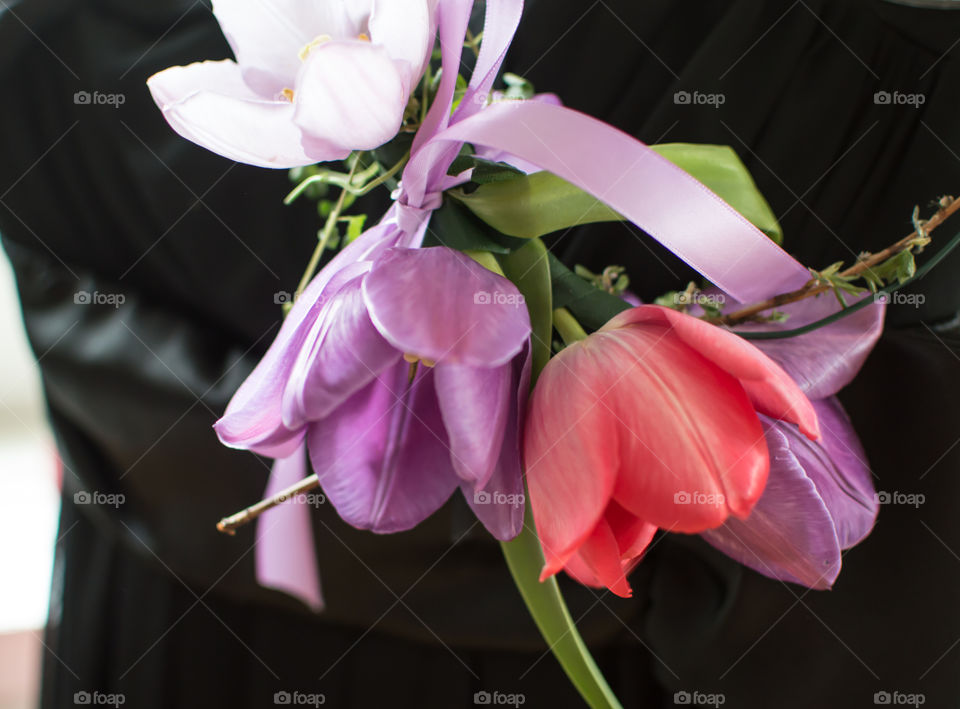 Dreamy Fairy Flower crown with red and lavender hanging next to  little black dress with satin sash closeup detail getting ready for celebration conceptual background 