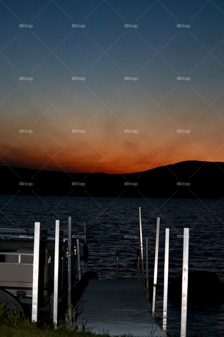 Dock at the lake at sunset in the Adirondack mountains 