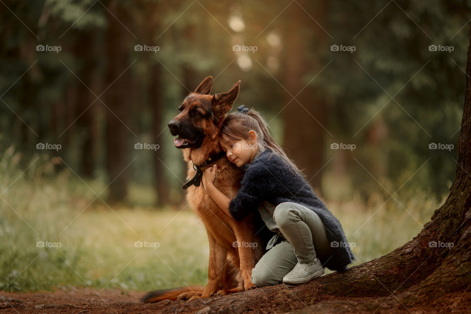 Little girl with dog in autumn park 