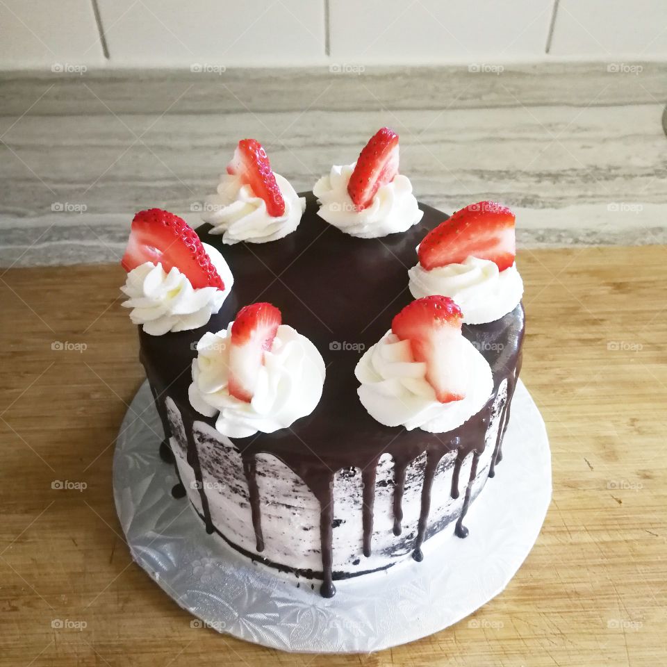 chocolate cake with ganache, strawberries, and whipped cream
