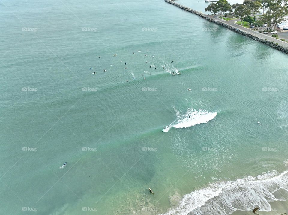 A group of surfers in sunny Southern California catch some waves in Laguna Beach