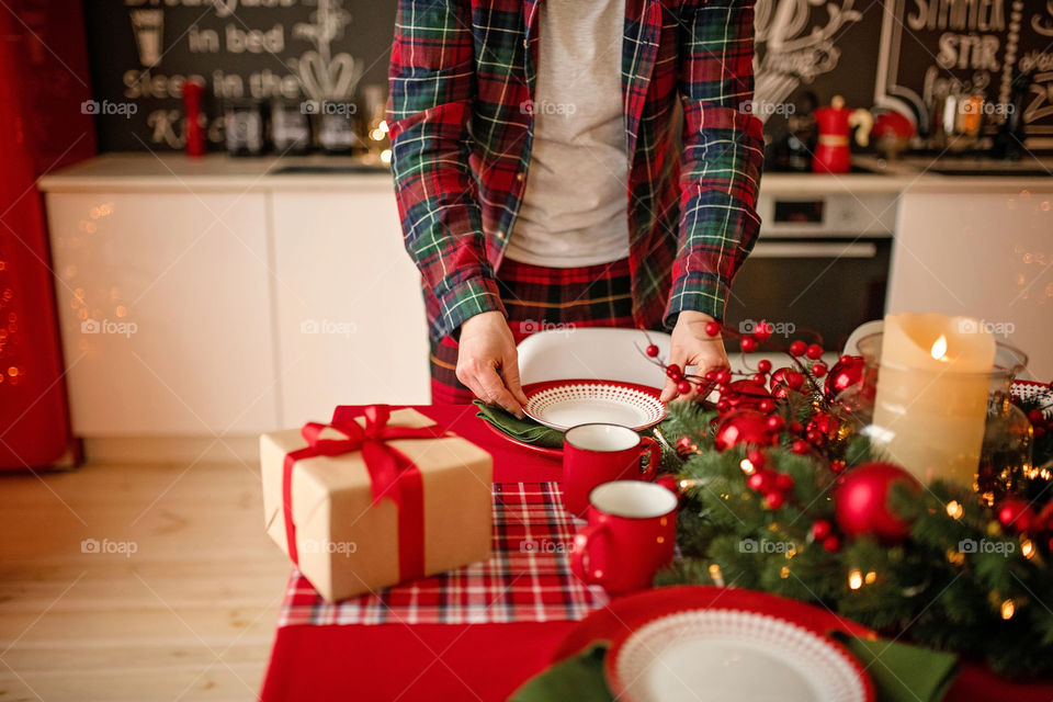 man sets a beautiful decorated winter table for a festive dinner.  Merry Christmas and Happy New Year.