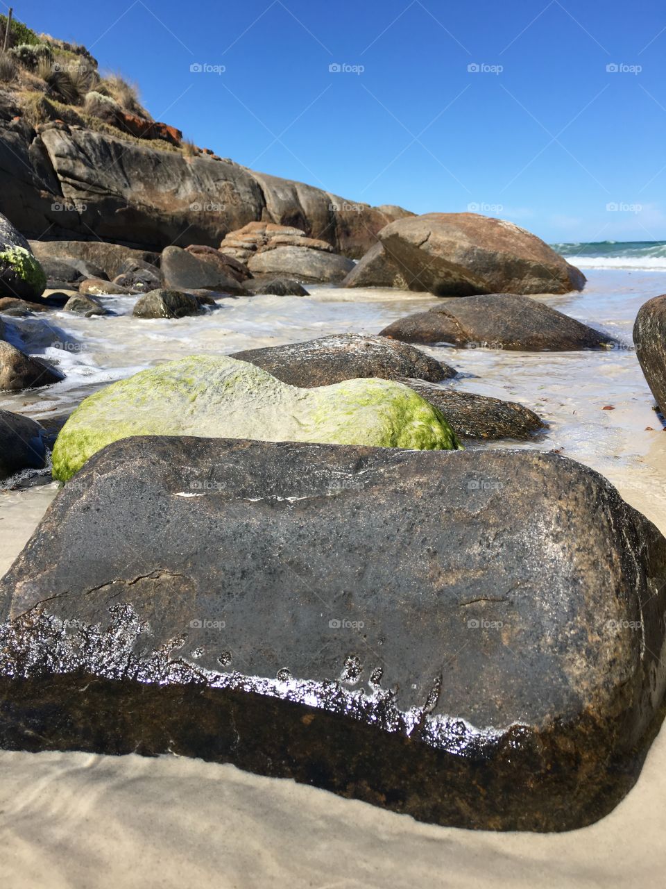 Rising tide in remote beach, rocks in the foreground, south Australia 