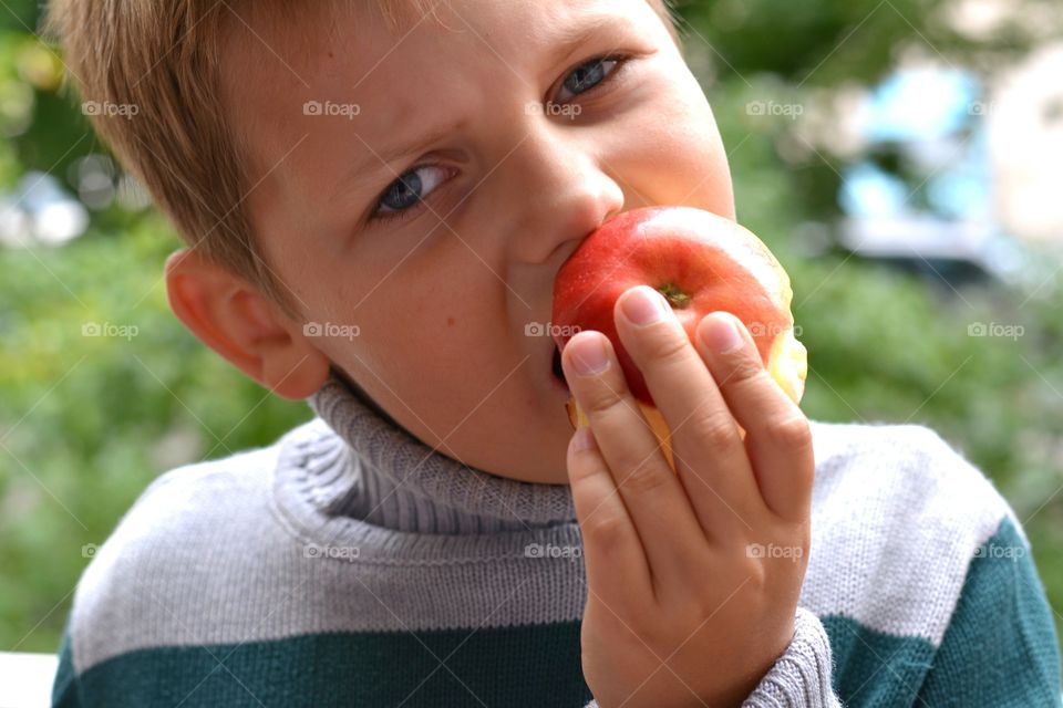 child boy with apple 🍎 portrait close up green background