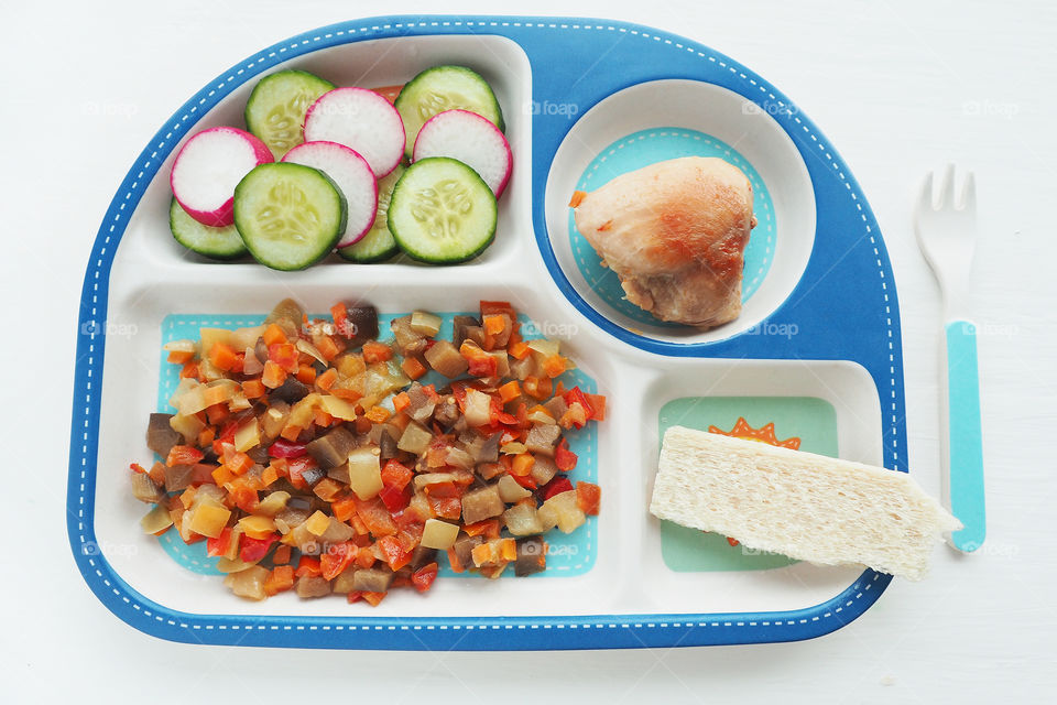children's plate with compartments with a complex lunch: stewed vegetables, cucumber and let's decide, I'll pass, chicken meat.