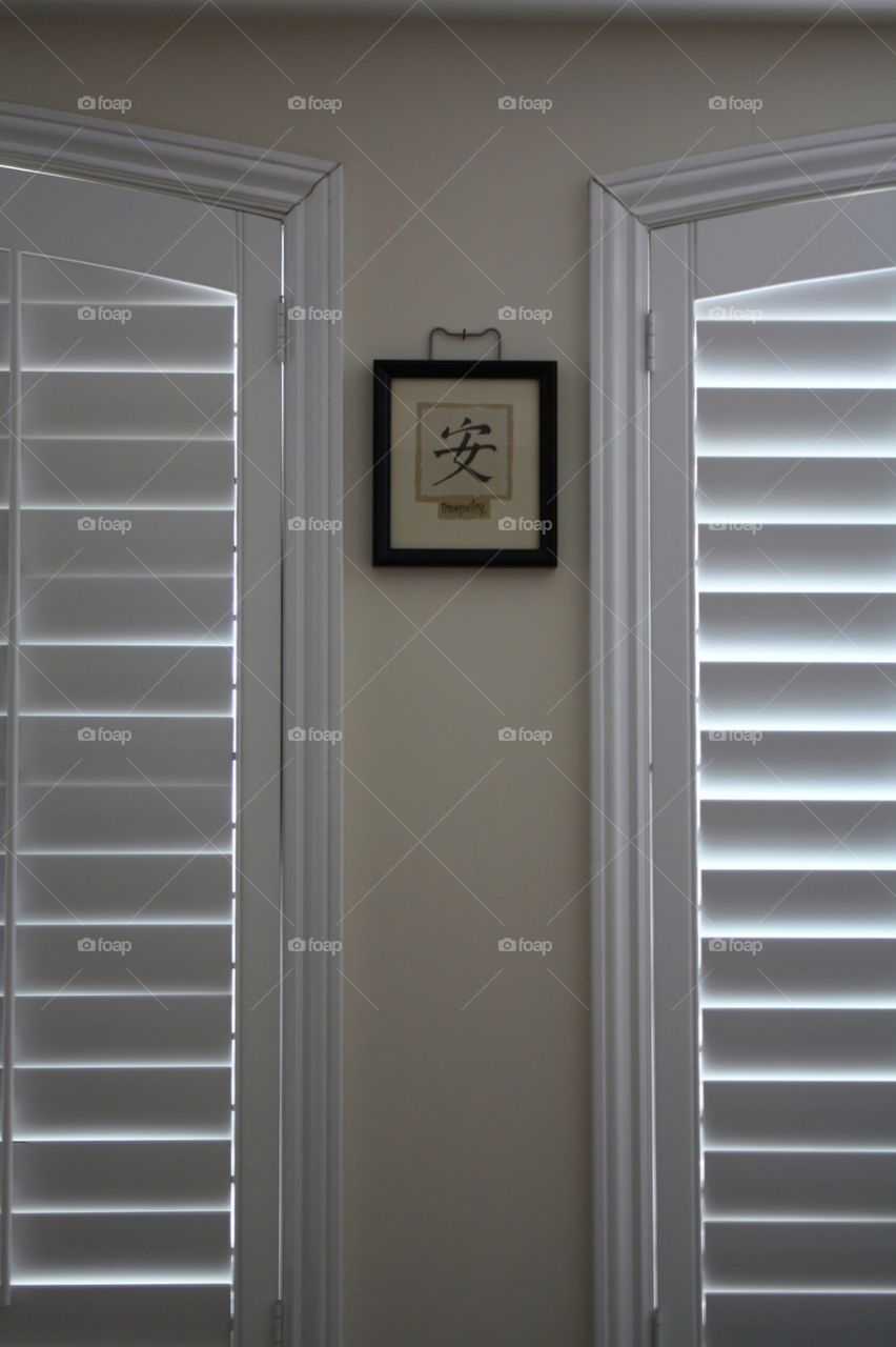 Picture frame hanging in between two windows 