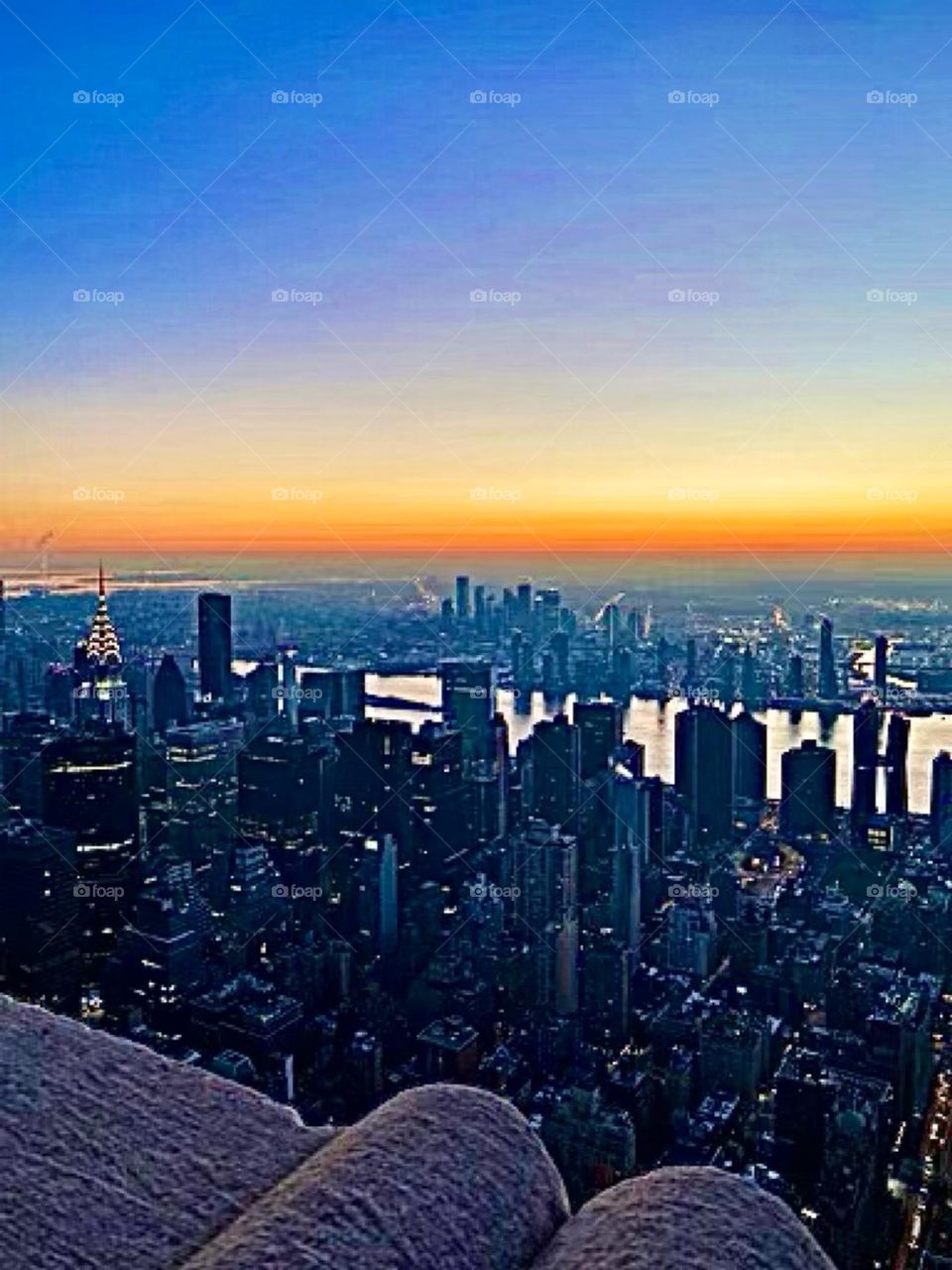 An arial view of the outer New York City boroughs across the East River and parts of Manhattan photographed at sunset time just before nightfall. 2022. Hypnotic Productions