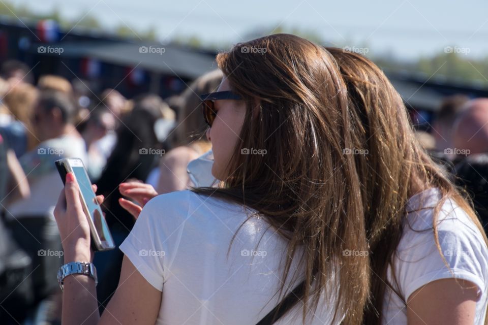 Two girls at a festival checking on their phone
