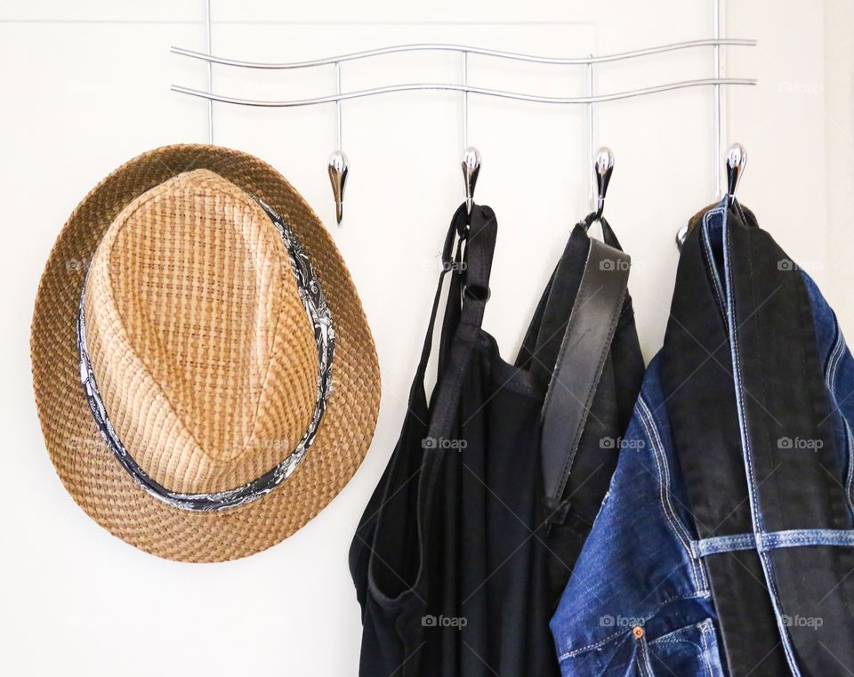 Jeans and hat on a hanger against white background