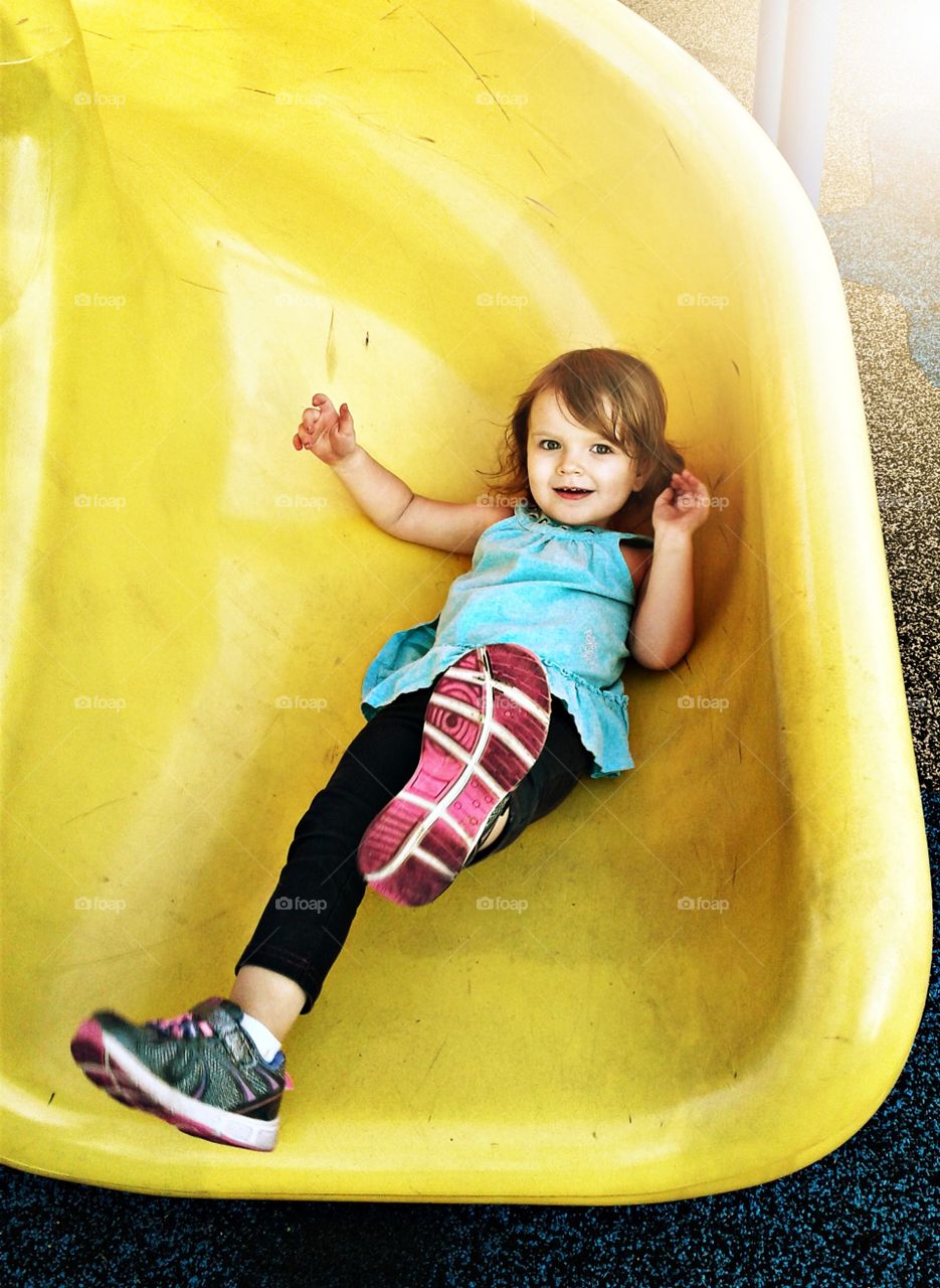 Small girl playing on slide