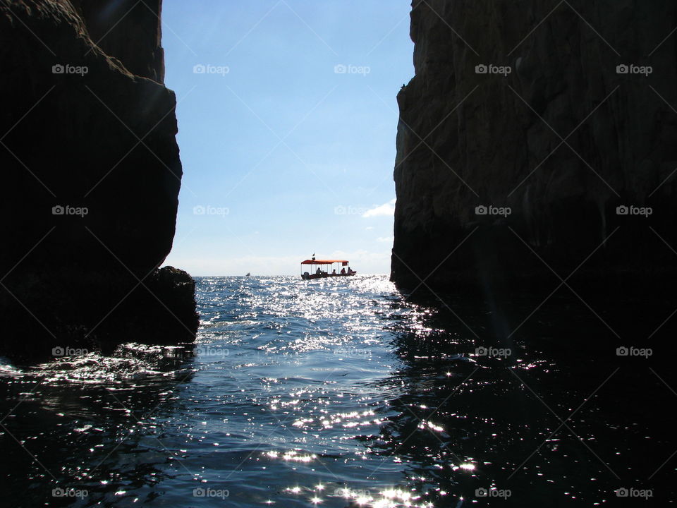 View through cliff of boat sailing on water