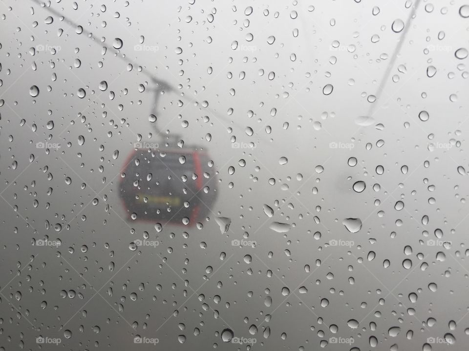 Cable car hanging among rain storm