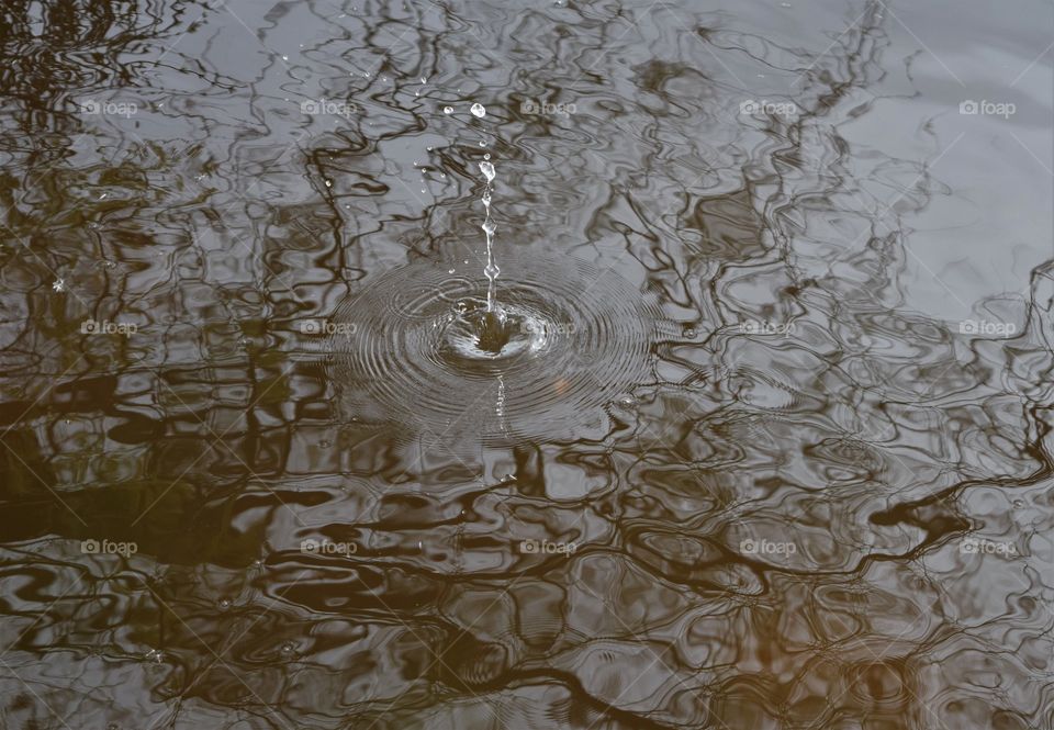 An object hitting the water creates an opposite reaction in the form of water droplets jumping from the surface
