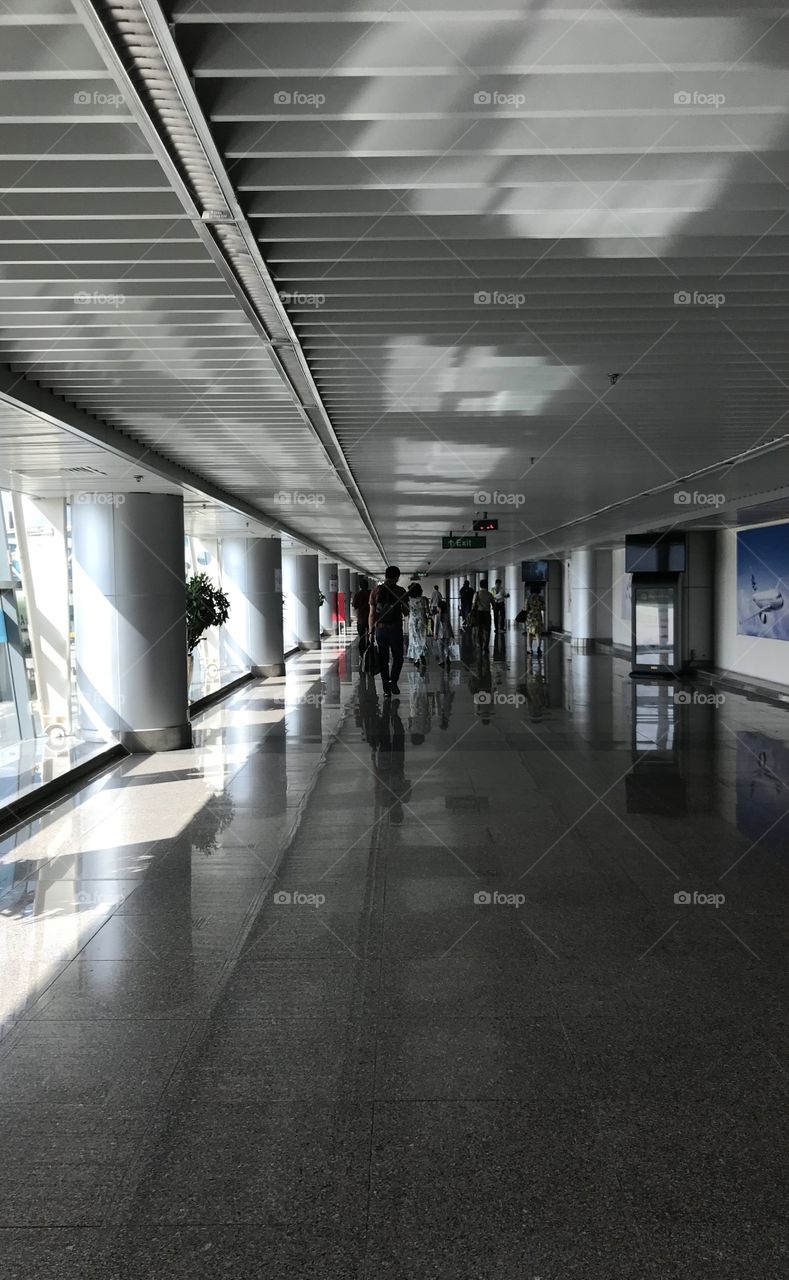 Light and shadows , silhouettes of passengers and pillars at the airport