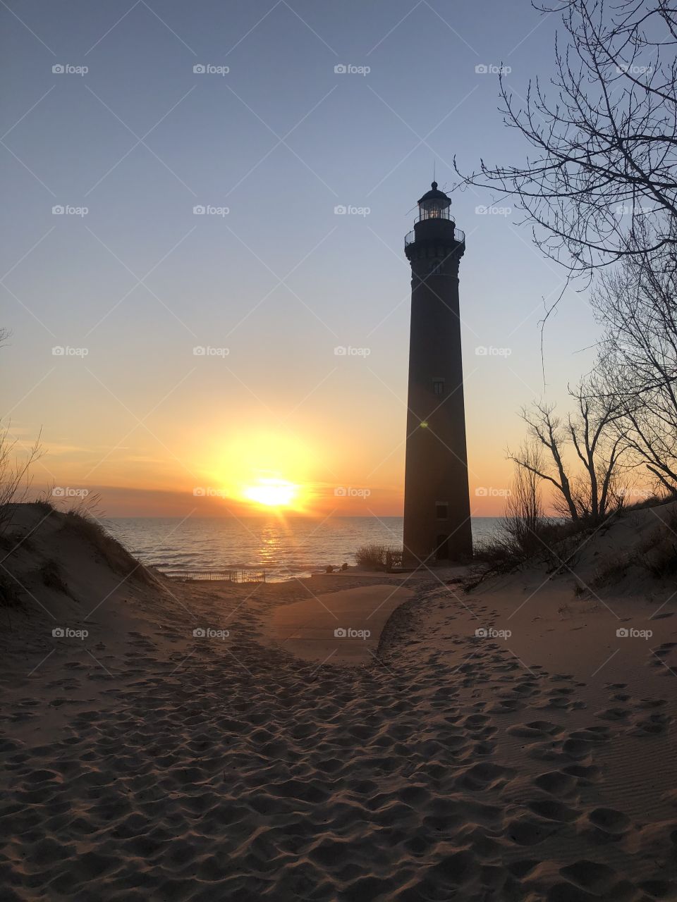 Lighthouse at Lake Michigan with the sunset in the background 
