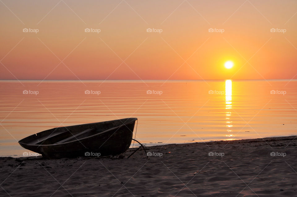Boat silhouette on the seashore at sunset