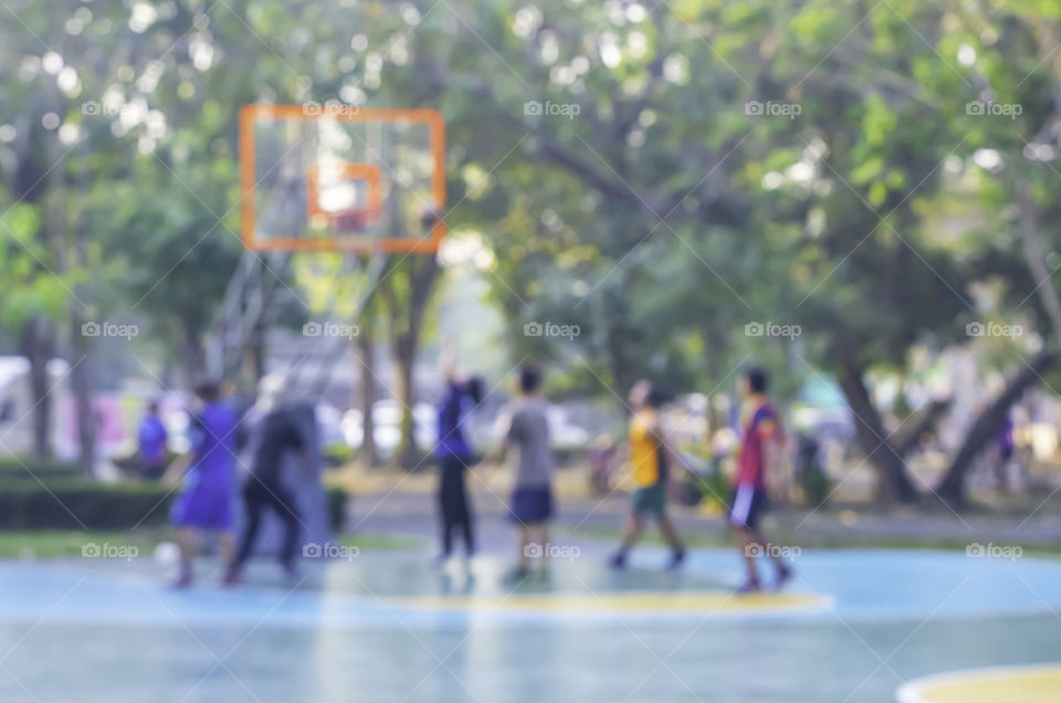 Blurry image of elderly men and women playing basketball in the morning.