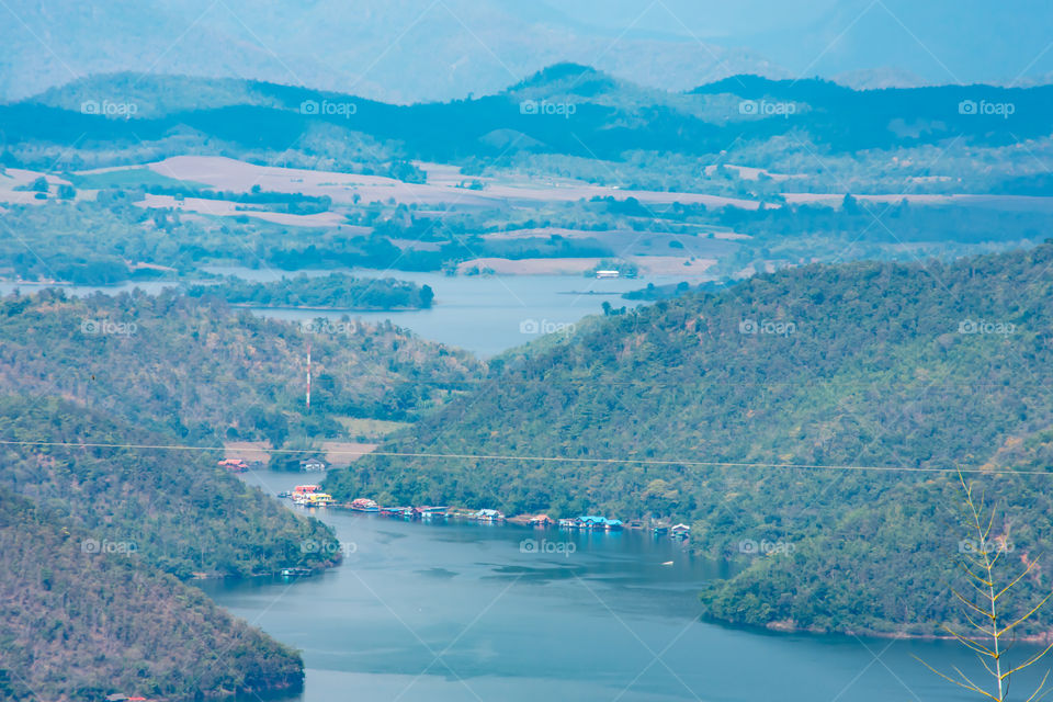 The beauty inside the dam and the houseboat on the bright sky at Sri Nakarin dam , Kanchana buri in Thailand.