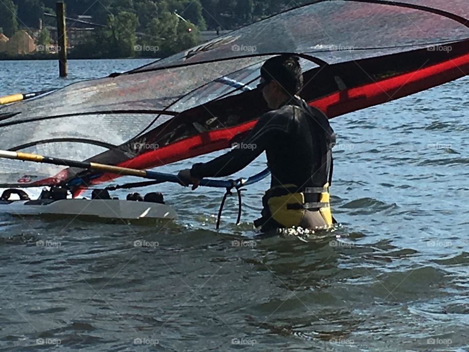 Man in water about to go windsurfing