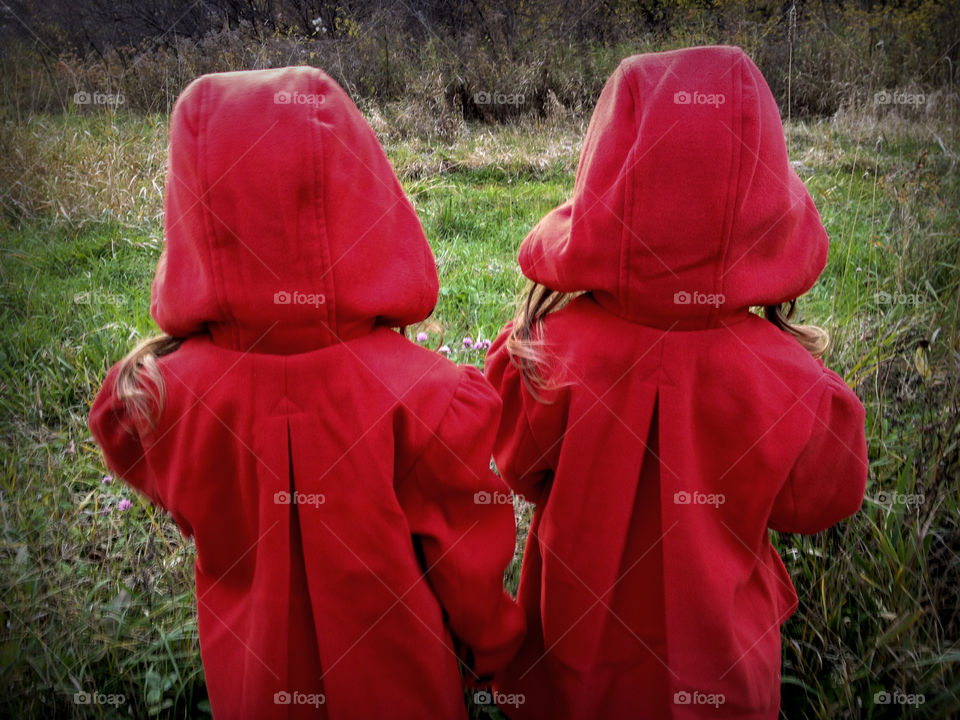 Two girls wearing red hooded robe