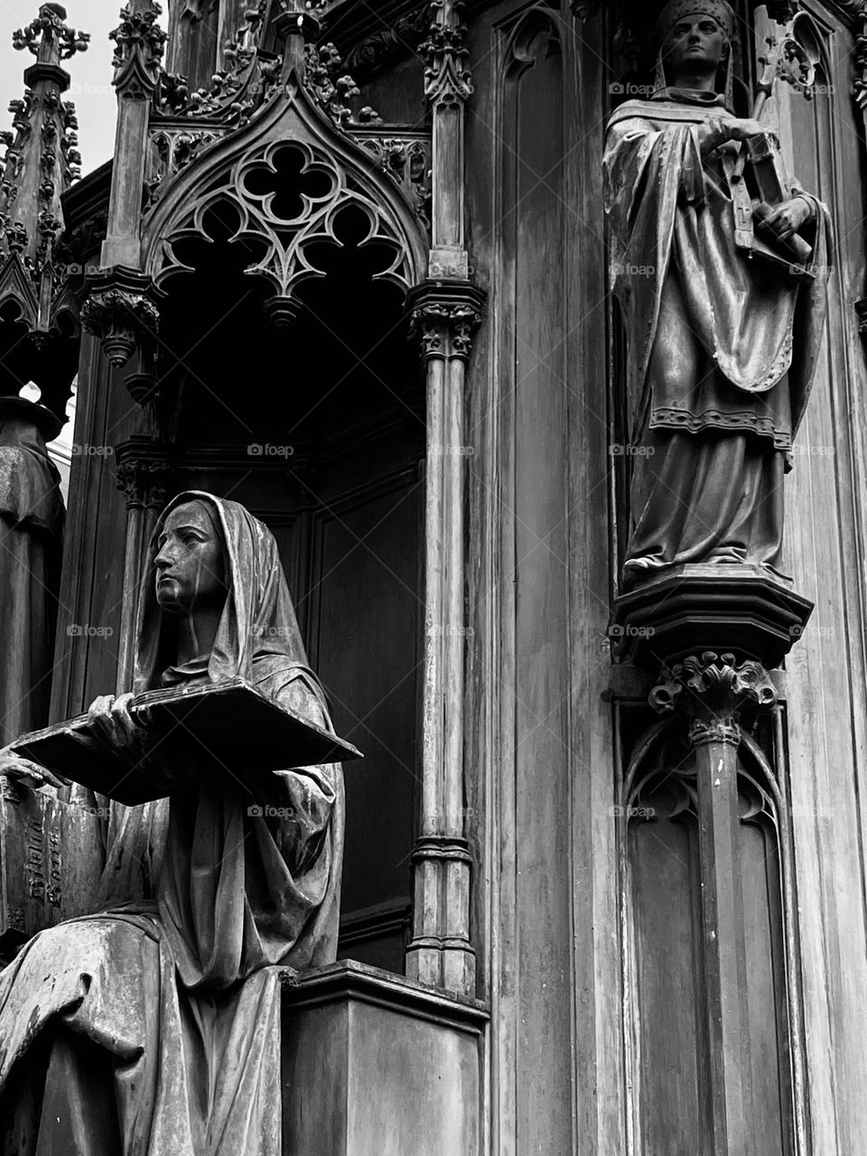 Black and white gothic statue of a man reading a book in Prague.