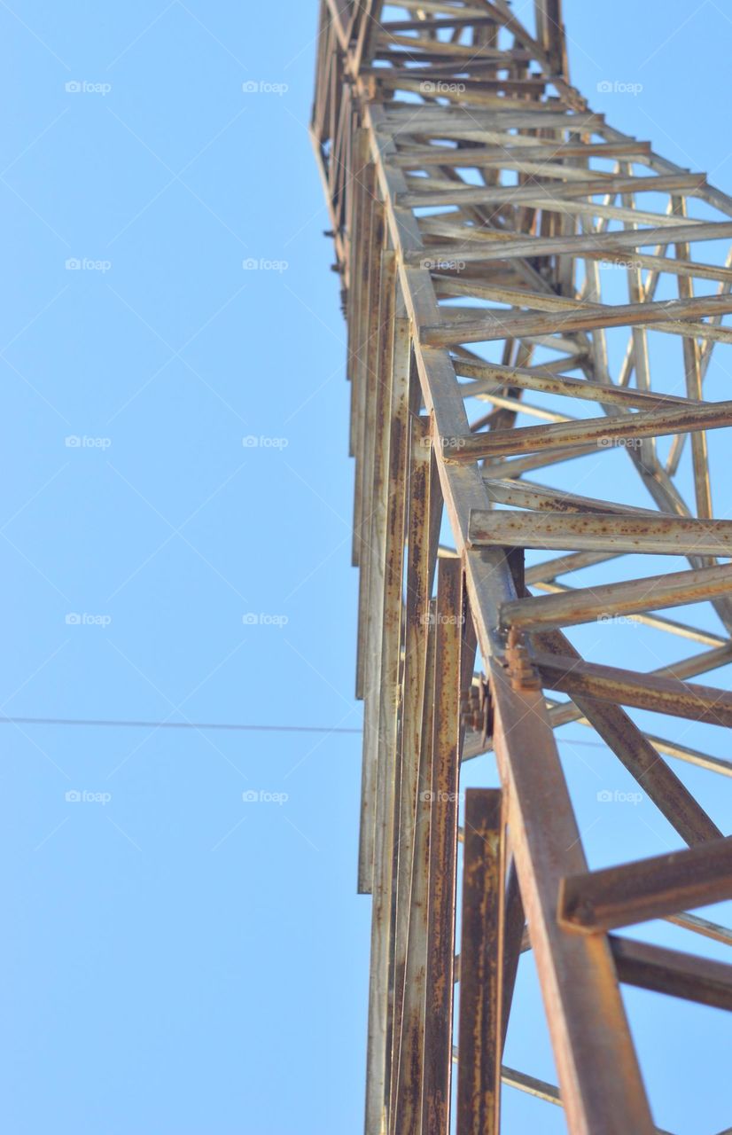 metal structure goes into the sky, high-voltage pole made of metal mast blue sky