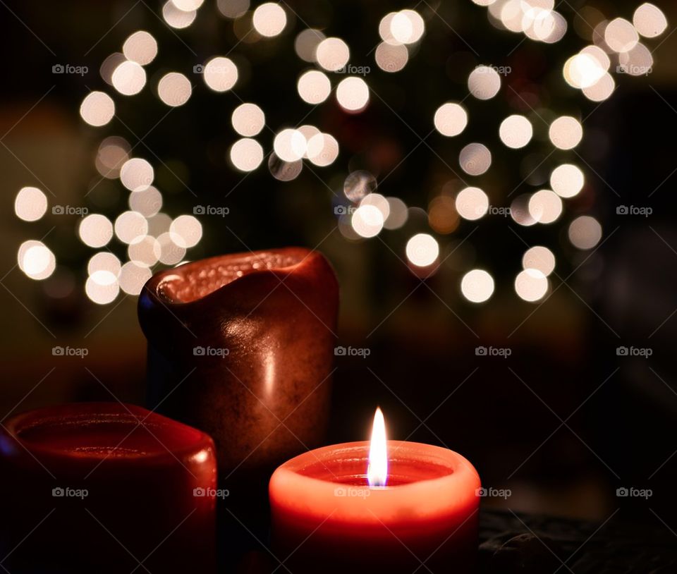 Lit candles with lights in background