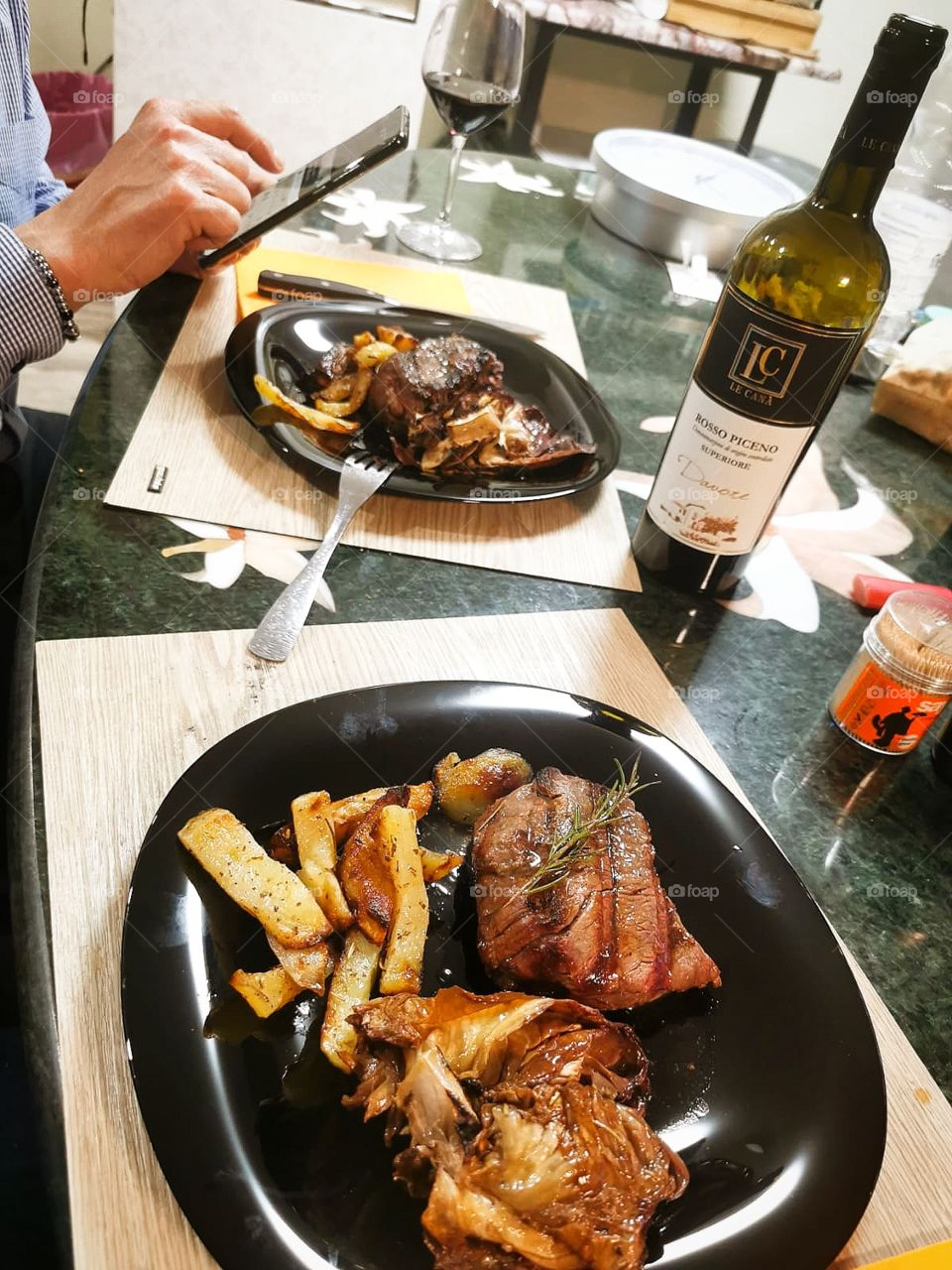 Dinner for two.  Grilled meat with chips and a bottle of wine