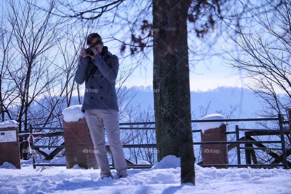 A boy taking a photo on the snow