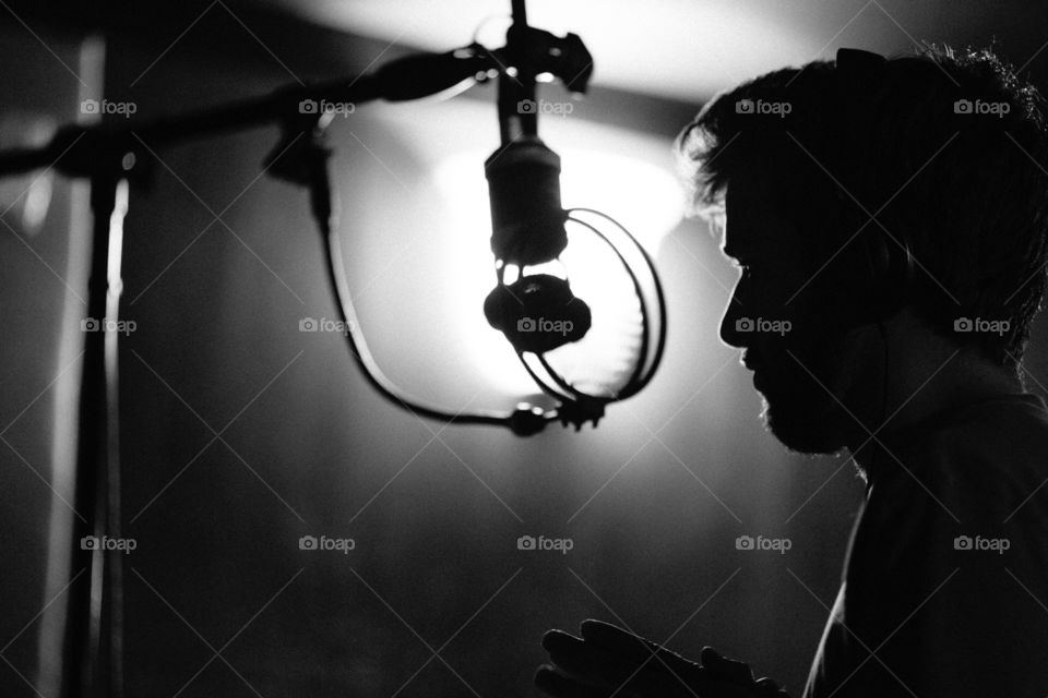 Man singing into microphone in studio. Studio microphone recording vocals 
