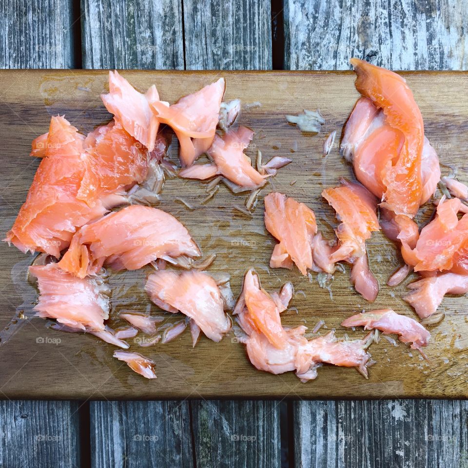 Flaky cured salmon on a wooden cutting board