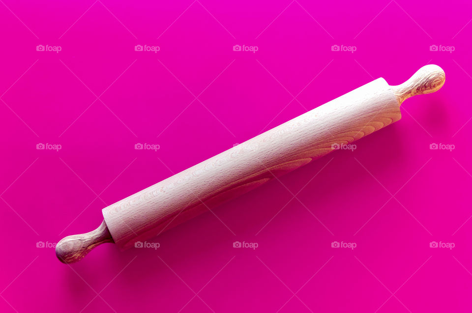 Rolling pin on pink background