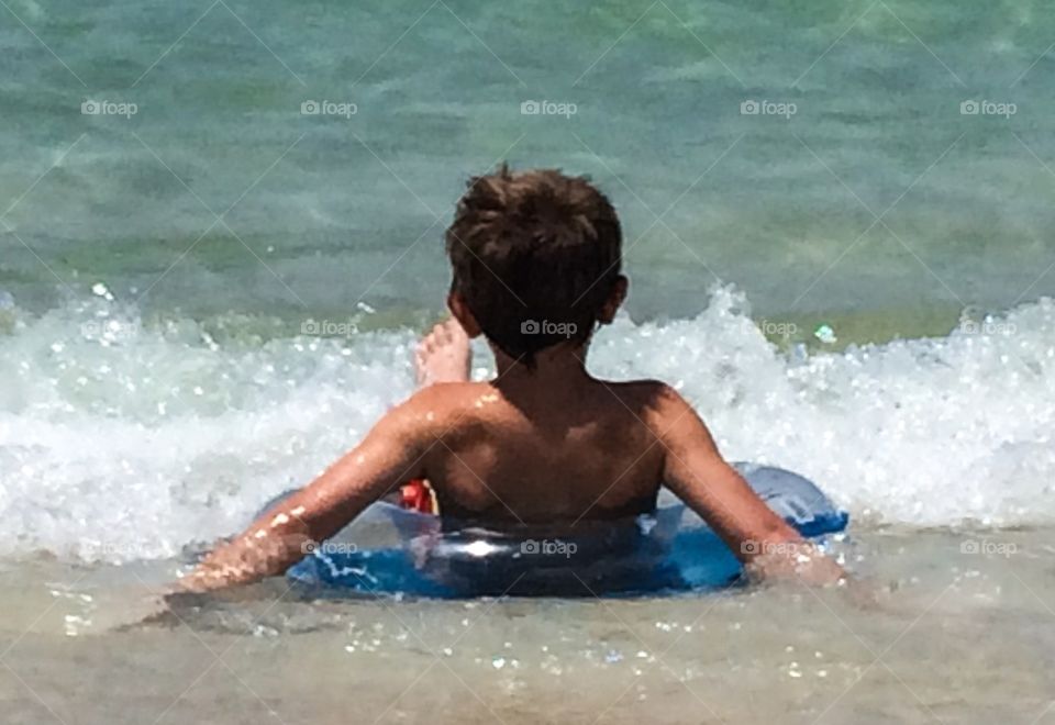 Boy at beach in tube 