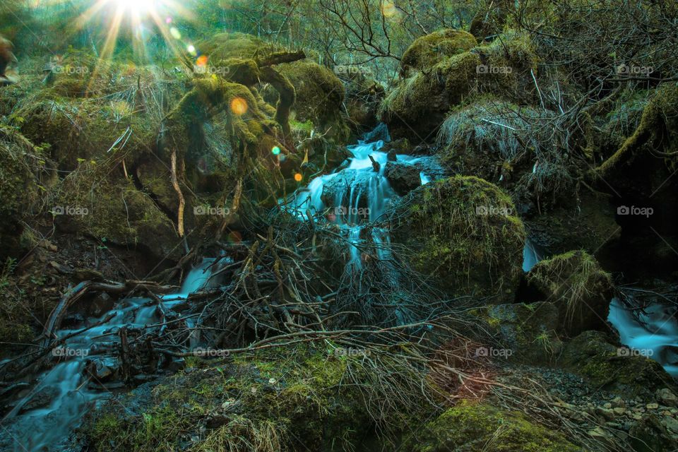 Small waterfall in Iceland with a sun star

