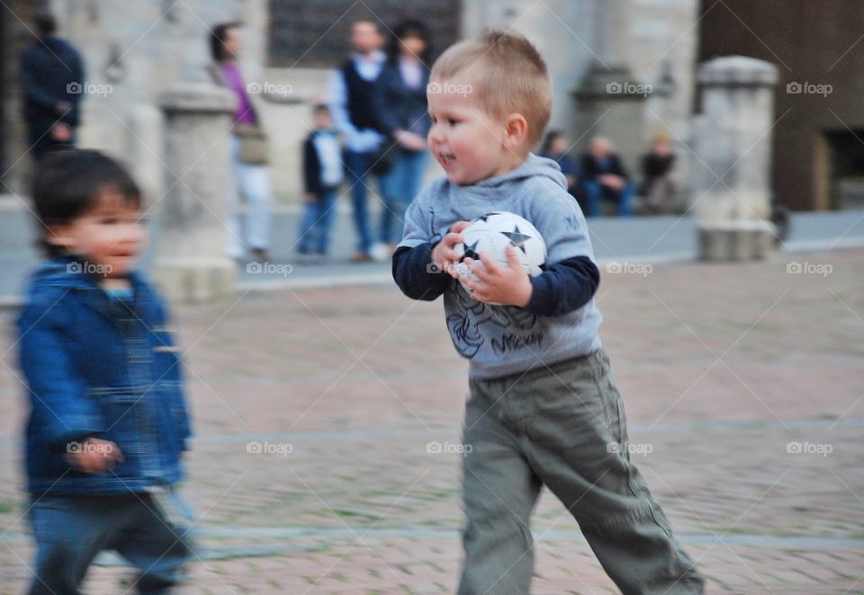 Hold it!. A little boy with a little soccerball is happy that he's holding it