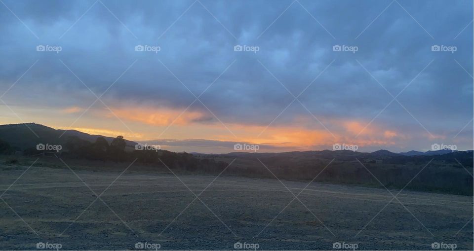 The beginning to a beautiful pastel orange and blue sunset out in the countryside. 