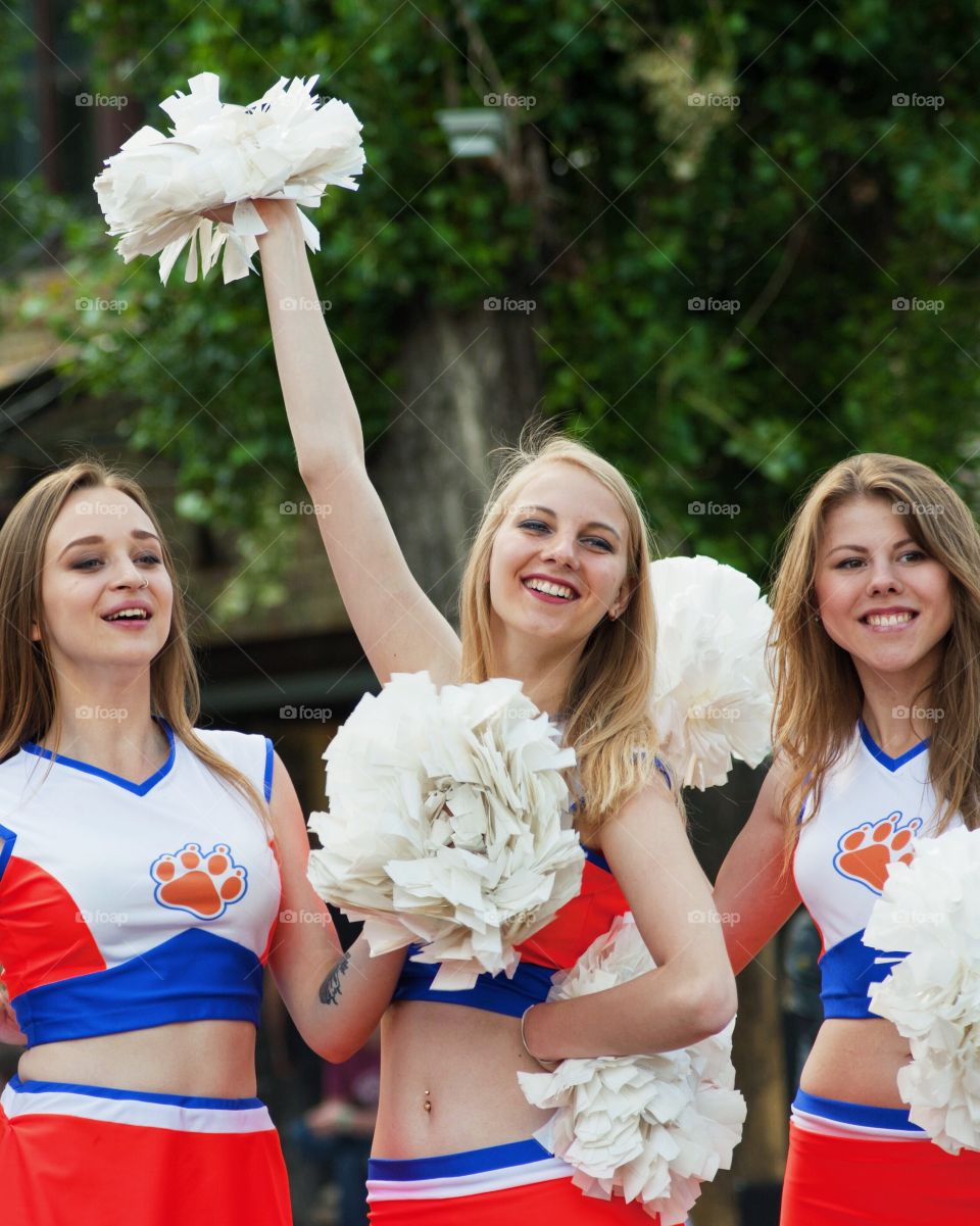 Cheerleaders in uniform holding pom-poms