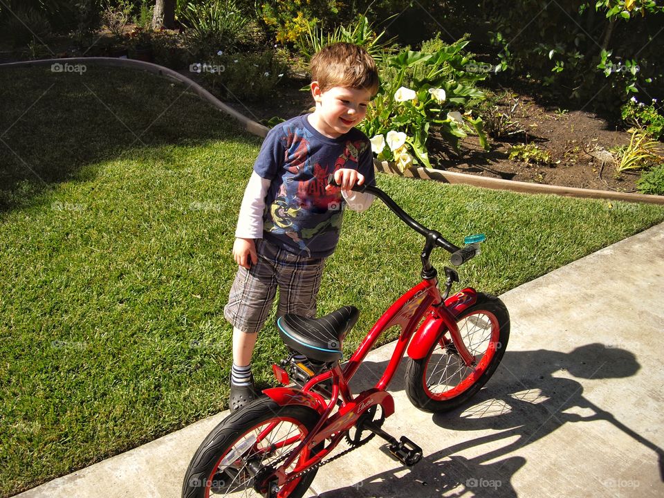 Young Boy With His New Red Bike
