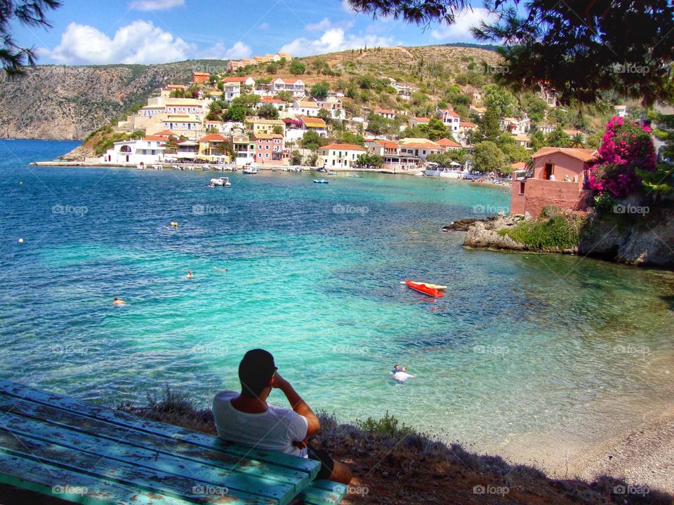 Man sat admiring the view of breathtaking Assos, Kefalonia 