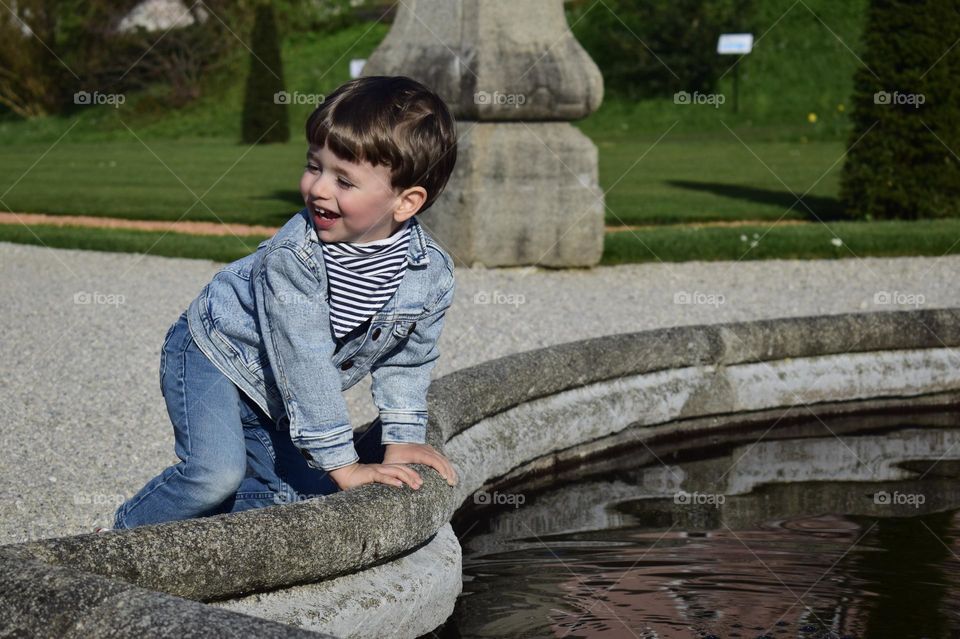 Little boy standing in front of the fountain