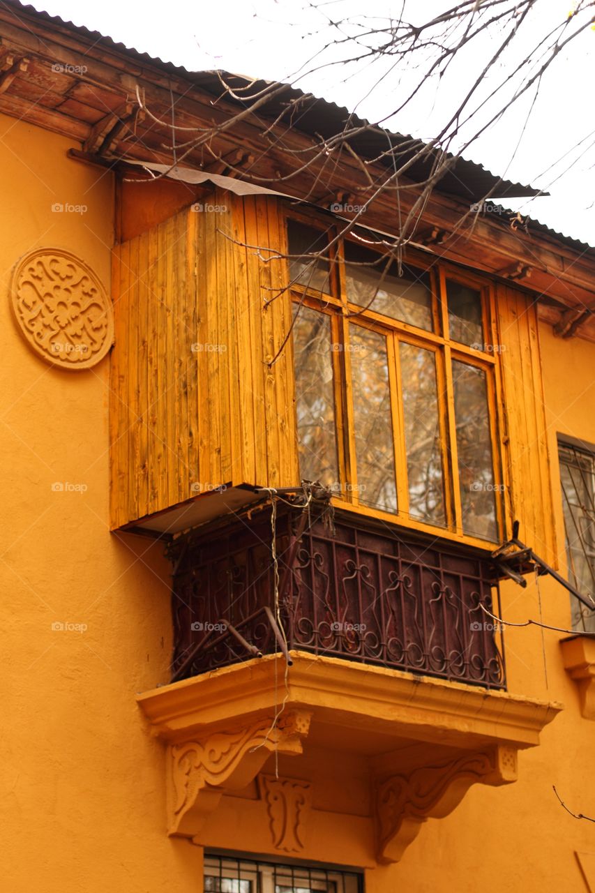 Yellow balcony of an old house in autumn