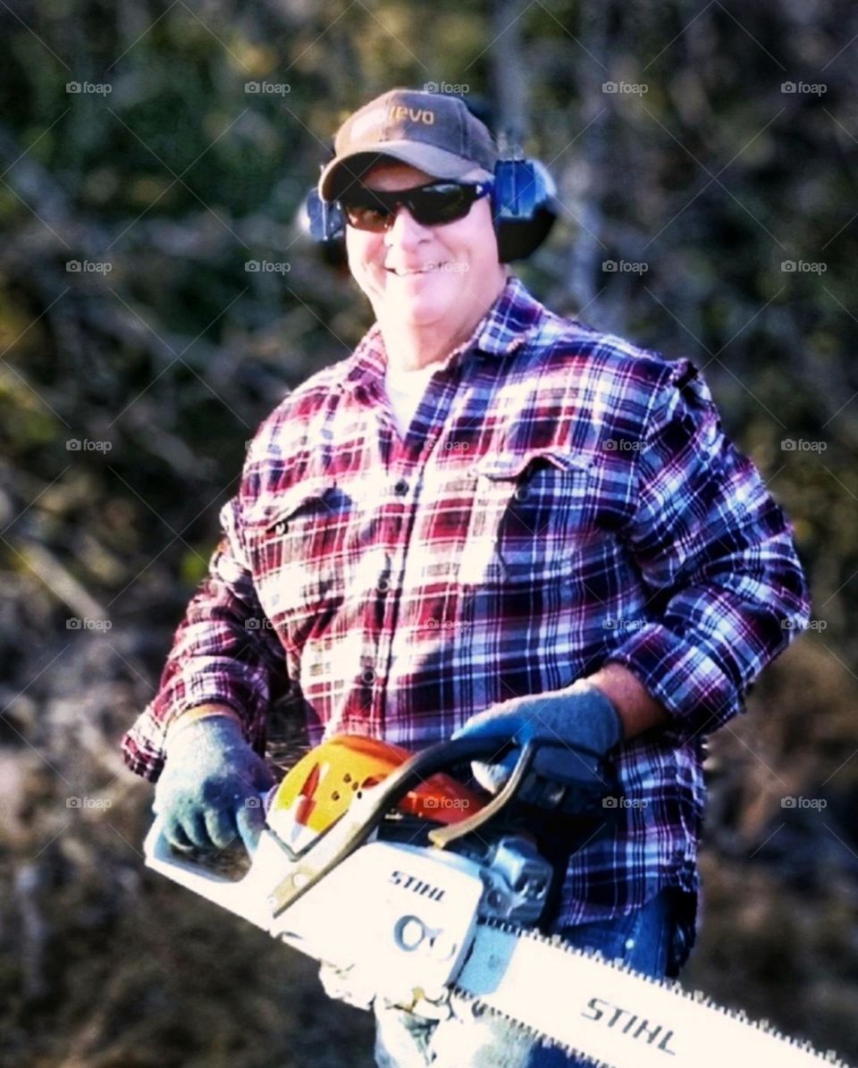 Happy Man with a Stihl chainsaw outdoors