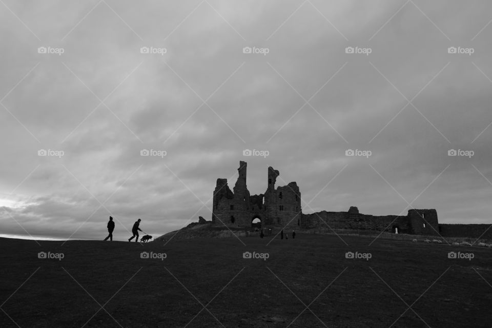 Husband being pulled by the dog up the hill to the castle followed not far behind by my son ... sky full of rain clouds .. feel that b&w suits the eerie surroundings and rain clouds forming in the sky