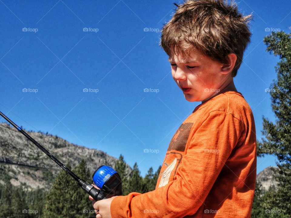 Young Fisherman With His Rod And Reel. Boy With Fishing Pole
