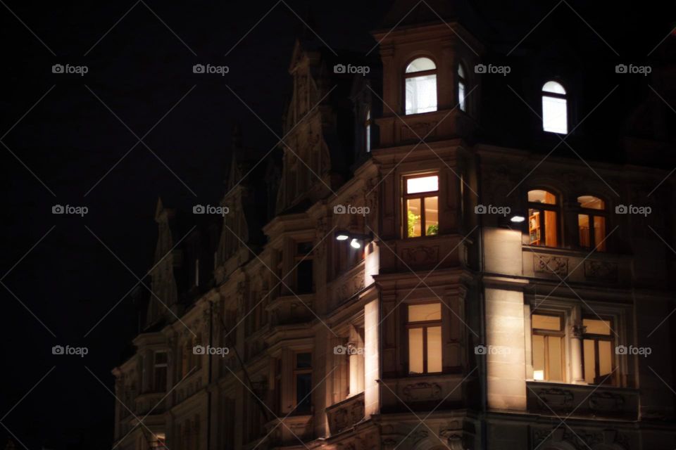 Warm golden light shines from windows in a historic house at night