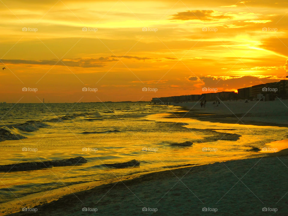 The sun  shone brilliantly and the water in the ocean glittered invitingly! A golden glow spread across the sky as the sun chased the dark clouds away! The sunset is free, so go outside and capture it!